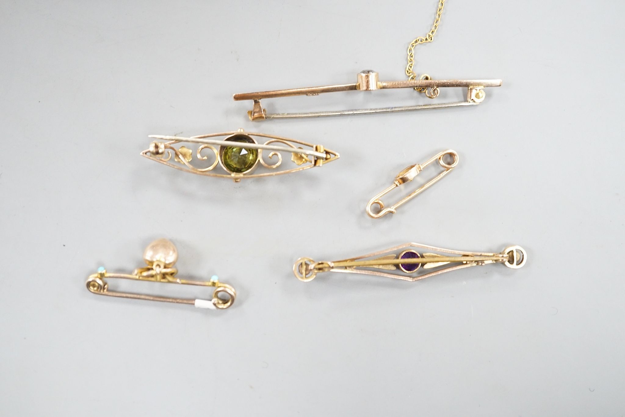 Five assorted early 20th century yellow metal and gem set brooches, including one 9ct and one with turquoise set heart drop and one with peridot, largest 62mm, gross 11.7 grams.
